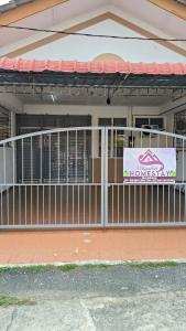 a building with a gate with a sign on it at D'Raudhah Homestay Binjai Kemaman 