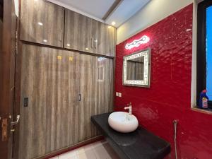 Un baño con lavabo y pared roja. en 6 Marla Full House In DHA 9 Town, en Lahore