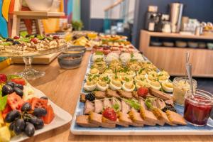 ヴロツワフにあるHotel Villa Art Novis City Centerのテーブルの上にたくさんの料理が並んだビュッフェ +84枚の写真