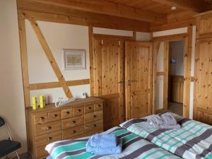 a bedroom with a bed and a dresser at Pension zum Yachthafen in Waren
