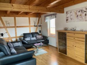 a living room with a leather couch and a table at Pension zum Yachthafen in Waren