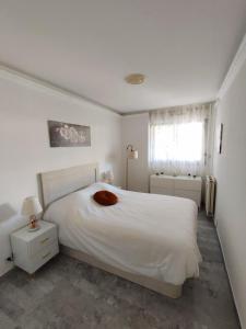 a white bedroom with a white bed and a window at Mas de Tanit Appartement & Vacance deLuxe in Antibes