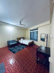 una camera da letto con un letto, un divano e un tavolo di Priya Apartment a Pokhara