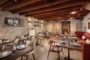 a restaurant with tables and chairs and a fireplace at Boutique Hotel San Rocco in Brtonigla