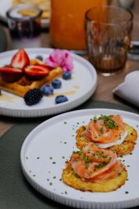 two plates of food on a table with fruit at Pullman Riga Old Town - Renovated 2025 in Rīga