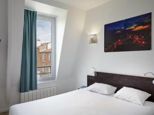 a bedroom with a white bed with a window at Aparthotel Adagio Access Paris Philippe Auguste in Paris