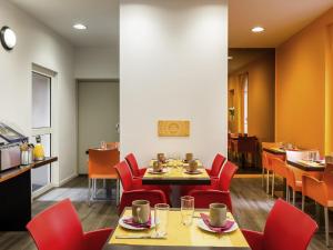 a dining room with red chairs and a table at Aparthotel Adagio Access Paris Philippe Auguste in Paris