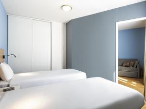 two beds in a room with a mirror at Aparthotel Adagio Access Paris Quai d'Ivry in Ivry-sur-Seine +50 photos