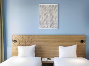 Dos camas una al lado de la otra en una habitación. en Aparthotel Adagio Access Paris Quai d'Ivry, en Ivry-sur-Seine 55 fotos más
