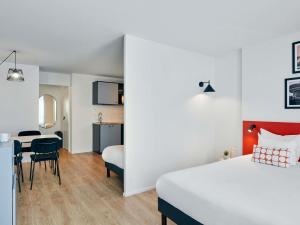 a hotel room with a bed and a table and chairs at Aparthotel Adagio Access Paris Vanves - Porte de Versailles in Vanves