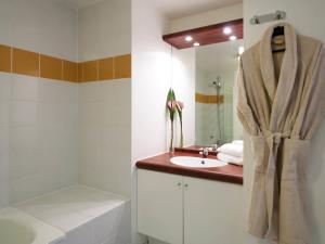 a bathroom with a sink and a mirror at Aparthotel Adagio Access Paris Vanves - Porte de Châtillon in Vanves
