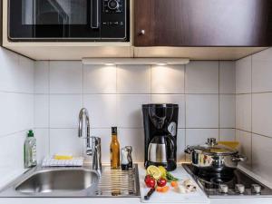 a kitchen counter with a sink and a microwave at Aparthotel Adagio Access Paris Vanves - Porte de Châtillon in Vanves