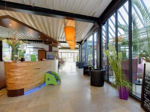 a lobby of a store with windows and plants at ibis Styles Leipzig in Radefeld