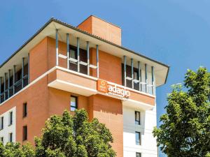 a tall red brick building with a sign on it at Aparthotel Adagio Access Toulouse Jolimont in Toulouse +36 photos