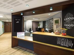 a man sitting at a counter in a restaurant at Aparthotel Adagio Access Rennes Centre in Rennes