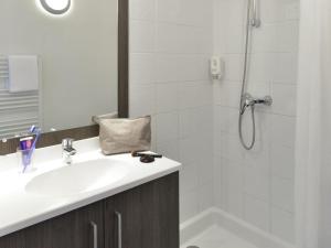 a bathroom with a sink and a shower at Aparthotel Adagio Access Toulouse St Cyprien in Toulouse +40 photos