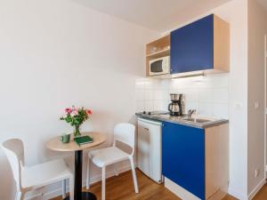 a small kitchen with a small table and a sink at Aparthotel Adagio Access Paris Saint-Denis Pleyel in Saint-Denis +51 photos
