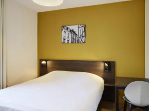 a bedroom with a bed and a table and a window at Aparthotel Adagio Access Poitiers in Poitiers