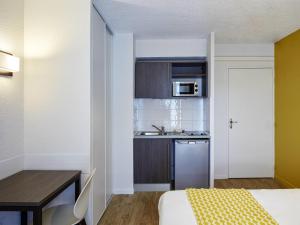 Habitación pequeña con cocina, cama y mesa. en Aparthotel Adagio Access Poitiers, en Poitiers 56 fotos más