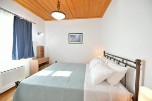 a bedroom with a bed with a wooden ceiling at Zoe's and Leonard's Houses in Hydra