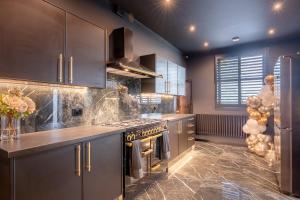 a kitchen with stainless steel cabinets and a stove at Brierley Club Hideaway Chic 7 Star Retreat in Rishton