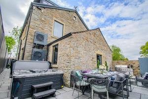a patio with a table and chairs and a building at Brierley Club Hideaway Chic 7 Star Retreat in Rishton