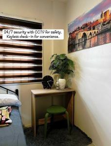a room with a desk with a green chair next to a bed at Casa Ariana in Pulilan