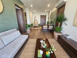 a living room with a couch and a table at The inner Home, Cozy Healing Suite, Vinhomes Ocean Park in Gia Lâm Pho