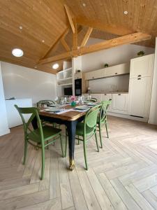 a dining room with a table and green chairs at L'Escale - Charming Seaside house by Harbor in Cancale