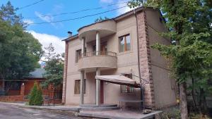 a building with a balcony and a table in front of it at Mon Ami Tsaghkadzor in Tsaghkadzor