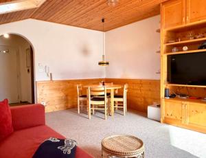 Una sala de estar con una mesa y un televisor. en Apartment Almhof Vinschgau - Val Venosta, en Morter