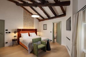 a bedroom with a bed and a green chair at Boutique Hotel San Rocco in Brtonigla +102 photos