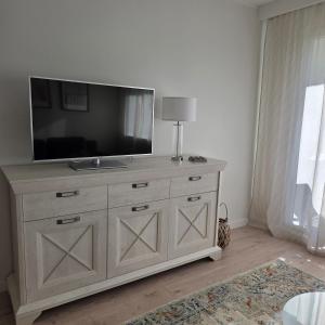 a television on top of a dresser in a room at Morski Spokój Kołobrzeg apartment in Kołobrzeg