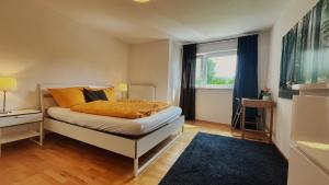 a bedroom with a bed with orange pillows and a window at Wohnung 1 Altstadt in Ulm