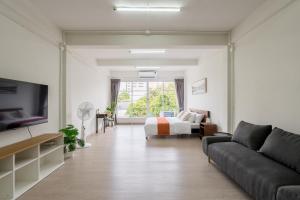 a living room with a couch and a bed at Glow House Sukhumvit 54 in Bangkok