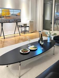 クリにあるDodi's 3room APTの黒いコーヒーテーブルに食べ物とワインの皿が2枚 +24枚の写真