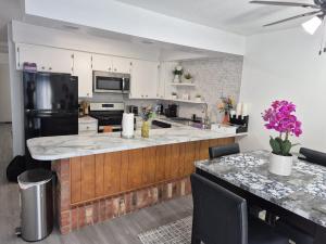 a kitchen with a black refrigerator and a counter at Emmanuel Fulton Park Condominium in Tulsa