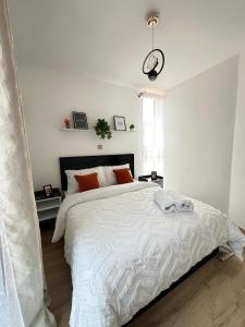 a bedroom with a white bed with a clock on the wall at Dream Nook - One Bedroom Apt in Tatu City in Tatu City