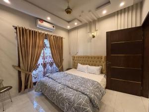 un dormitorio con una cama y una ventana en 6 Marla Full House In DHA 9 Town, en Lahore