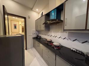 Una cocina con gabinetes blancos y una encimera negra. en 6 Marla Full House In DHA 9 Town, en Lahore