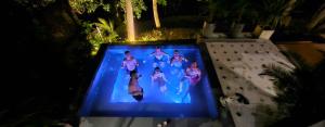 a group of women walking in a swimming pool at night at Villa Xiav - Flipside Adventures in Bản Kin