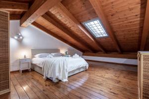 a bedroom with a large bed with a wooden ceiling at Morning Glory in Fiumicino