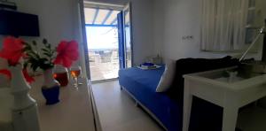 a living room with a blue bed and a window at Haus Asterakia in Aliko Beach