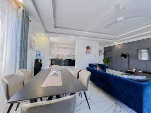 モンバサにあるGina Apartmentsのダイニングルーム(テーブル、青いソファ付)