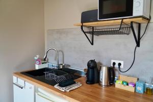 a kitchen counter with a sink and a microwave at Appartement Nr 1 Centre Ville 2 personnes 50m2 rénové in Tarbes