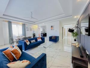 モンバサにあるGina Apartmentsの青いソファ2つとテレビのあるリビングルーム