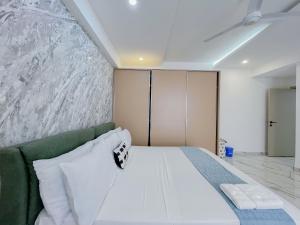 モンバサにあるGina Apartmentsのベッドルーム(白いベッド1台、緑のソファ付)