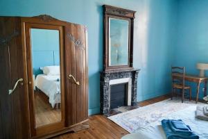 a blue room with a fireplace and a mirror at Appartement Nr 1 Centre Ville 2 personnes 50m2 rénové in Tarbes +4 photos