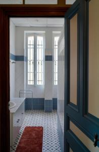 a bathroom with a tub and a sink and a door at Appartement Nr 1 Centre Ville 2 personnes 50m2 rénové in Tarbes