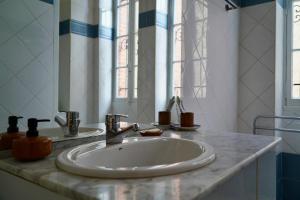 a bathroom with a white sink and a mirror at Appartement Nr 1 Centre Ville 2 personnes 50m2 rénové in Tarbes